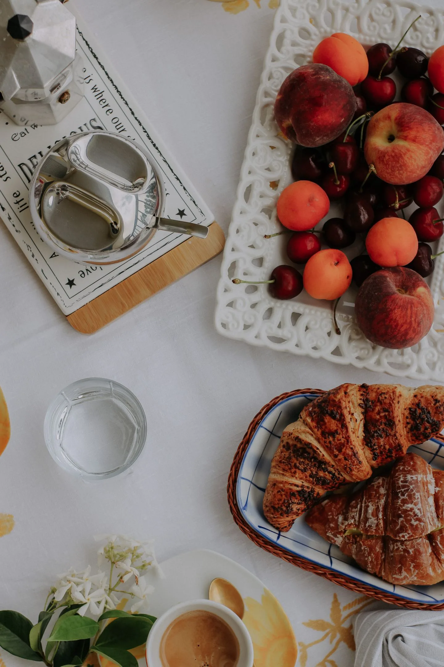 Croissanteja, hedelmiä ja kahvia aamiaispöydällä
